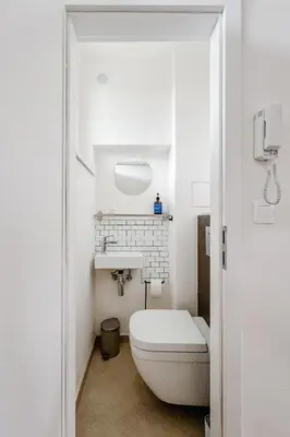 a white bathroom with a toilet and a sink at Prague Days - One Bedroom Apartment with AC and Workspace in Holešovice in Prague