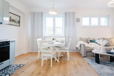 a white living room with a table and chairs at Prague Days - One Bedroom Apartment with AC and Workspace in Holešovice in Prague