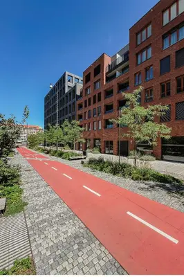 an empty red road in a city with buildings at Prague Days - One Bedroom Apartment with Garage Parking in Smíchov City in Prague