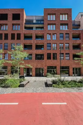 a brick building with a parking lot in front of it at Prague Days - One Bedroom Apartment with Garage Parking in Smíchov City in Prague