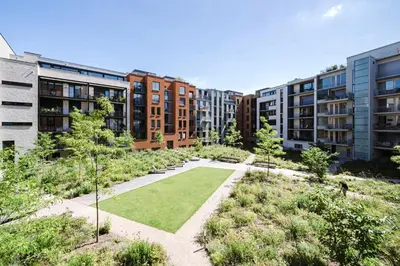 a garden in a city with tall buildings at Prague Days - One Bedroom Apartment with Garage Parking in Smíchov City in Prague