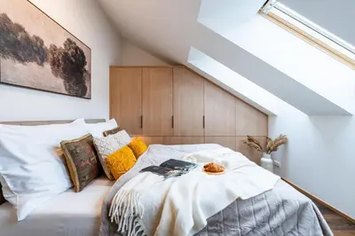 a bedroom with a white bed with pillows at Prague Days - Luxurious 3BDR Maisonette w AC & Balcony & Desk in Prague