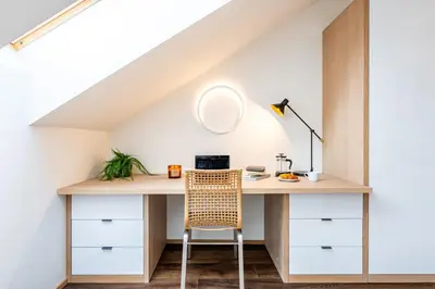 an attic room with a desk and a chair at Prague Days - Luxurious 3BDR Maisonette w AC & Balcony & Desk in Prague