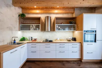 a kitchen with white cabinets and wooden ceilings at Prague Days - Luxurious 3BDR Maisonette w AC & Balcony & Desk in Prague