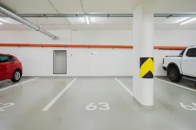 a parking garage with two cars parked in it at Prague Days - Family Friendly One-Bedroom Apartment with Balcony, TV & Netflix in Holešovice in Prague