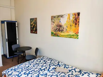 a bedroom with a bed and a painting on the wall at Comfortable 2 Bedroom Flat Free Parking Shared Kitchen in Prague
