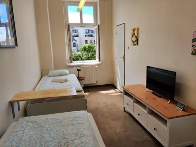 a room with two beds and a flat screen tv at Cozy Flat at Žižkov & Free Parking in Prague