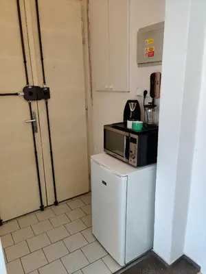 a kitchen with a microwave on top of a refrigerator at Cozy Flat at Žižkov & Free Parking in Prague