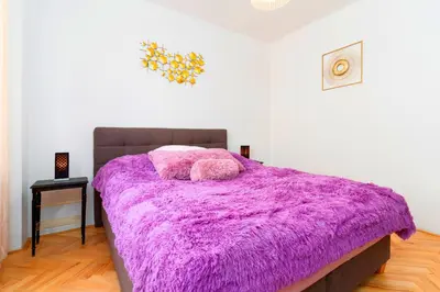 a bedroom with a purple blanket on a bed at Golden Heart Residence in Prague