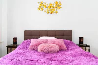 a bedroom with a pink bed with two night stands at Golden Heart Residence in Prague