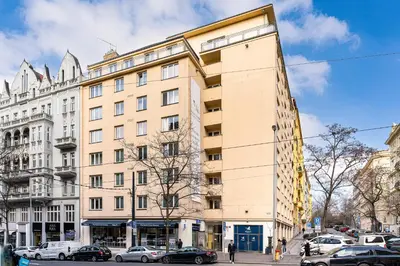 a tall building on a city street with parked cars at Golden Heart Residence in Prague