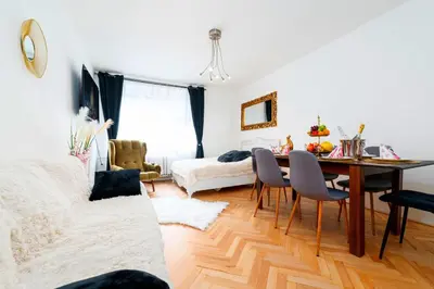 a living room with a dining room table and a bedroom at Golden Heart Residence in Prague