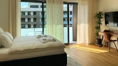 a bedroom with a bed and a desk and a piano at Urban studio with balcony in Prague
