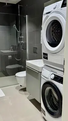 a bathroom with a washing machine and a toilet at Urban studio with balcony in Prague