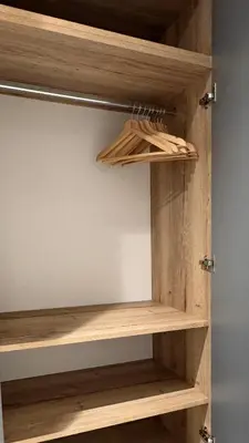 a cupboard with wooden shelves in a room at Urban studio with balcony in Prague