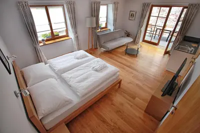 a bedroom with a bed and a living room at Penzion Dobré Časy in Poděbrady