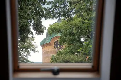 a clock tower is seen through a window at Penzion Dobré Časy in Poděbrady