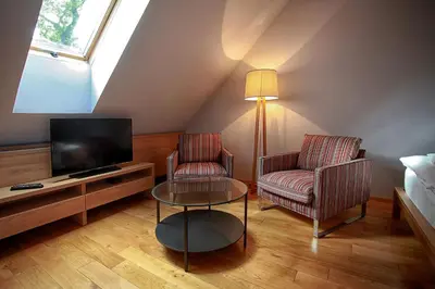 a living room with two chairs and a tv at Penzion Dobré Časy in Poděbrady