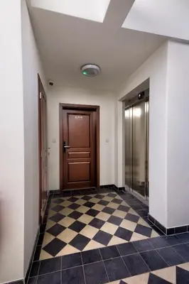 an empty hallway with a door and a checkered floor at Prague Urban Apartments 48 in Prague