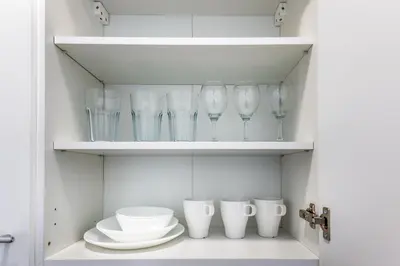 a cupboard filled with glasses and bowls and plates at Prague Urban Apartments 48 in Prague