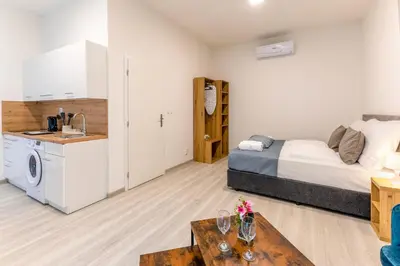 a bedroom with a bed and a kitchen with a sink at Prague Urban Apartments 48 in Prague