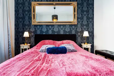 a bedroom with a pink bed with a mirror at Premium Dog Suite in Prague
