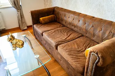 a living room with a brown couch and a glass table at Premium Dog Suite in Prague