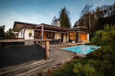 a house with a swimming pool and a deck at Modern Nature Retreat w Pool, PS5 & Hot Tube in Sázava
