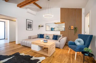 a living room with a couch and a table at Modern Nature Retreat w Pool, PS5 & Hot Tube in Sázava