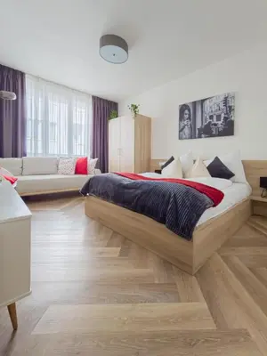 a bedroom with a large bed and a couch at Peaceful Apartment next to Jubilee Synagogue in Prague