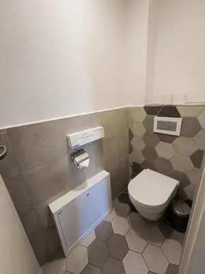 a bathroom with a toilet and a tiled floor at Peaceful Apartment next to Jubilee Synagogue in Prague