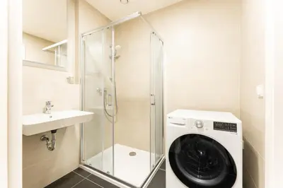 a washing machine in a bathroom with a sink at Rentero Fresh Apartment next to Prague City Center in Prague
