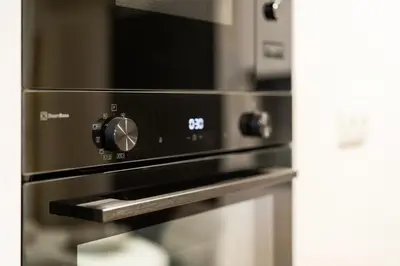 a stainless steel oven with a microwave on top at Rentero Fresh Apartment next to Prague City Center in Prague