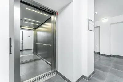 a hallway with a metal elevator in a building at Rentero Fresh Apartment next to Prague City Center in Prague
