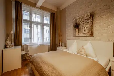 a bedroom with a large bed with a statue on the wall at Wenceslas Sq 3BDR Apartment in Prague