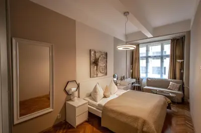 a bedroom with a bed and a mirror and a couch at Wenceslas Sq 3BDR Apartment in Prague