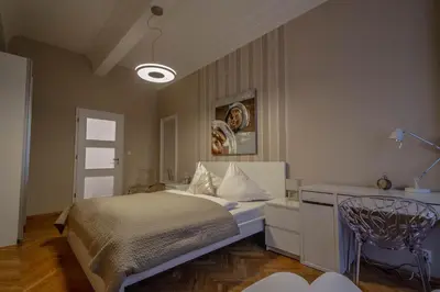 a bedroom with a bed and a desk and a lamp at Wenceslas Sq 3BDR Apartment in Prague
