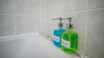 two bottles of soap sitting on a shelf in a bathroom at Tower Apartment in Prague