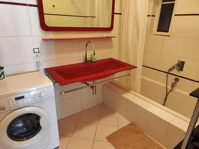a bathroom with a red sink and a washing machine at Tower Apartment in Prague
