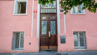 a pink building with a large wooden door at Tower Apartment in Prague