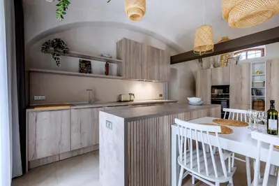 a kitchen with a counter and a table and chairs at Moderní a útulné studio na statku z roku 1880 in Prague