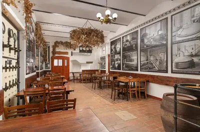 a restaurant with tables and chairs and pictures on the walls at Černokostelecký pivovar in Kostelec nad Černými Lesy