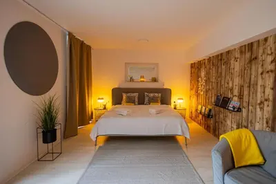 a bedroom with a large bed and a couch at Relax u potoka, vířivka, swimSpa, sauna