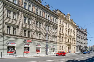 a red car parked in front of a large building at Blueground Holešovice view nr Vltava PRG-60 in Prague