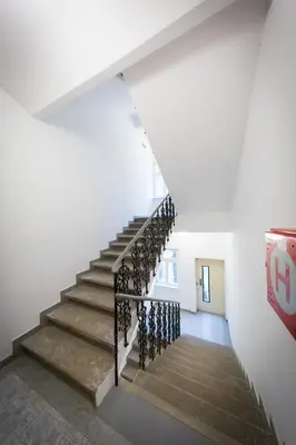 a stairwell in a white building with a stair railing at Bohéme Apartments Folimanka in Prague