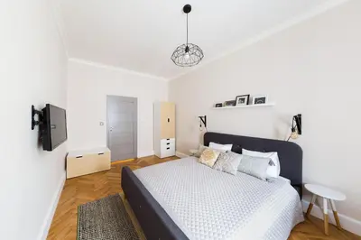 a white bedroom with a bed and a table at Bohéme Apartments Folimanka in Prague