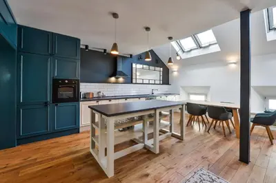 a kitchen with blue cabinets and a table and chairs at Funky lux 2 bedroom loft in the Old Town in Prague
