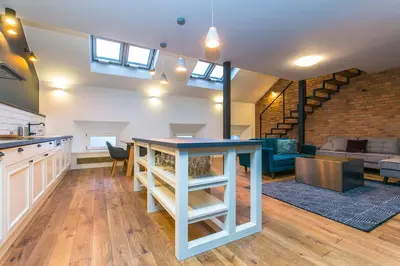 a kitchen and living room with a table and a couch at Funky lux 2 bedroom loft in the Old Town in Prague