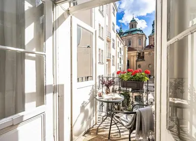 a balcony with a table and chairs and a building at Golden Prague Residence, Jáchymova Street in Prague