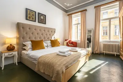 a bedroom with a large bed with yellow pillows at Golden Prague Residence, Jáchymova Street in Prague
